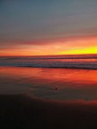 Scenic view of sea against dramatic sky during sunset