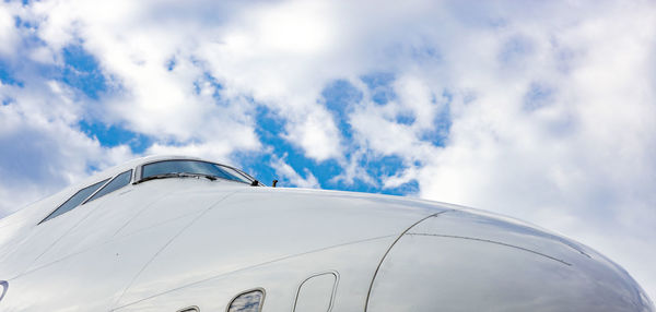 Cockpit of jet airplane against blue cloudy skies