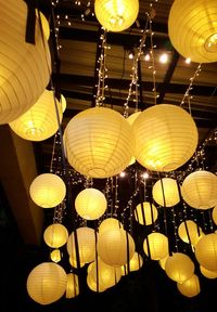 Low angle view of illuminated pendant lights hanging from ceiling