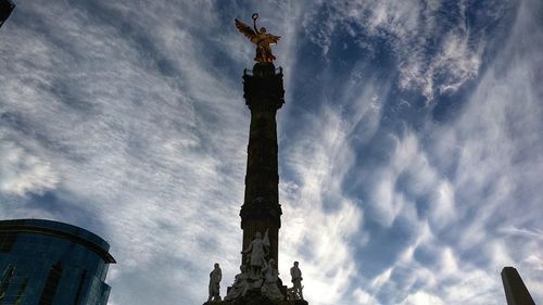 Low angle view of eiffel tower against cloudy sky