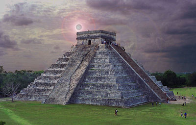 People at temple against cloudy sky