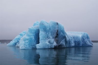 Ice floating on sea against sky