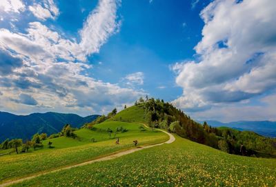 Scenic view of green landscape against blue sky