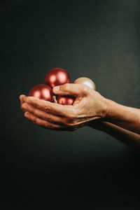 Cropped hand of man holding christmas ornament