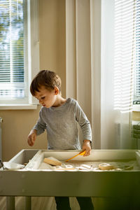 Boy playing in sandbox at home