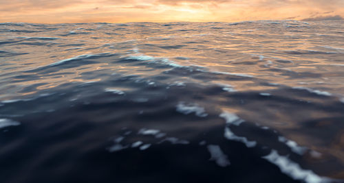 Surface level of sea shore against sunset sky