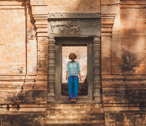 Rear view of woman standing at historical building