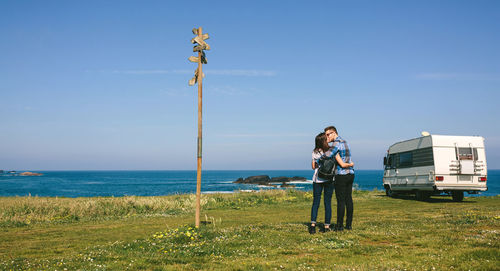 Rear view of couple kissing while standing on field