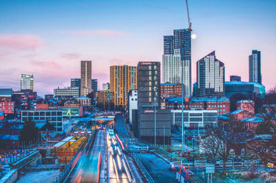 Aerial view of buildings in city against sky during sunset