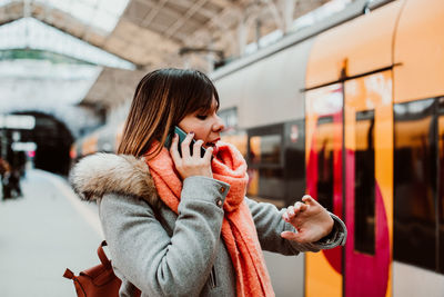 Full length of woman standing by train during winter