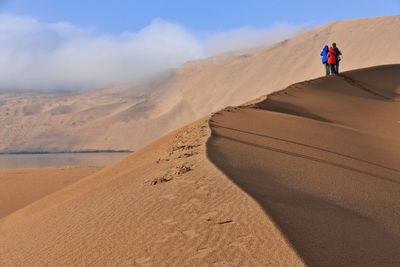 1130 tourists on a dune ridge between sumu jaran-sumu barun jaran lakes. badain jaran desert-china.