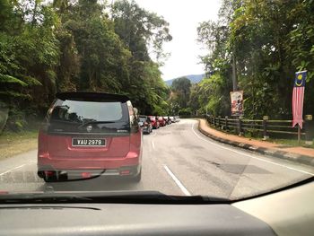 Cars on road in city seen through car windshield