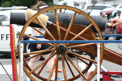 Cropped hand by cannon on street during fourth of july parade