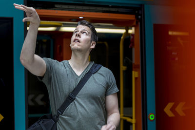 Young man with basketball standing at train entrance