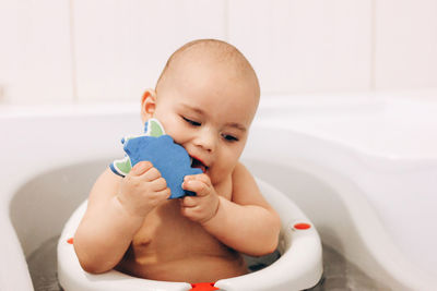 Cute baby playing with toy sitting at home