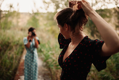 Woman with arms raised standing in sunlight