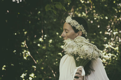 Woman in white blouse with flower bouquet and headband ii