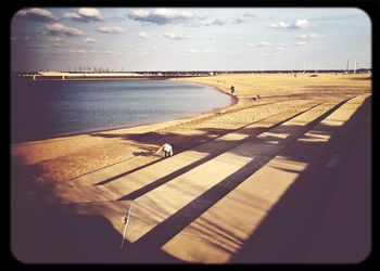 Pier on sea against cloudy sky