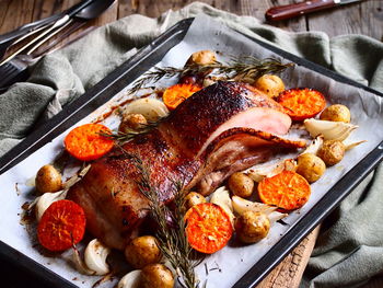 High angle close-up of roasted pork served in tray on table
