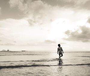 Full length of man standing on beach against sky