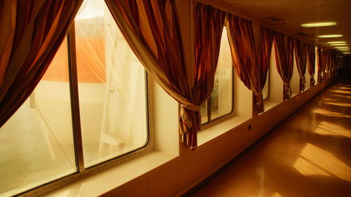 View of curtains on windows at corridor