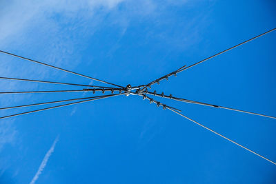 Low angle view of power lines against blue sky