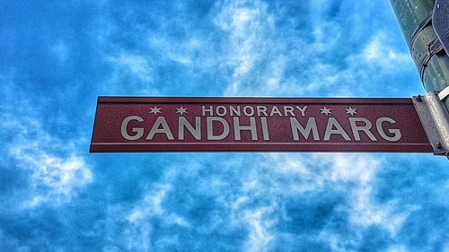 Close-up of road sign against blue sky