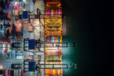 Night scene container ship loading and unloading in deep sea port, aerial view of business service 