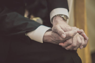 Midsection of man holding hands at home