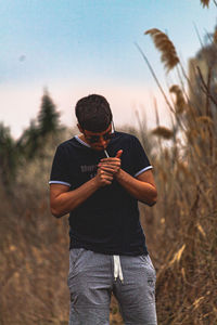 Man holding smart phone while standing on field