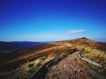 Scenic view of mountains against blue sky