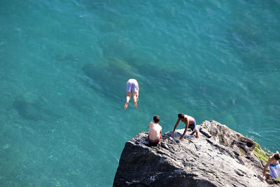 High angle view of people on rock in sea