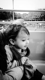 Boy with parent sitting in amusement park ride