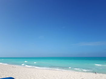 Scenic view of beach against clear blue sky