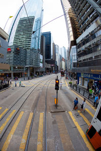 People on city street amidst buildings against sky