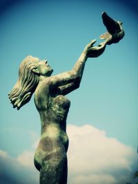Low angle view of statue against blue sky