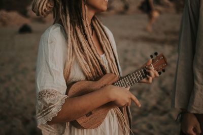 Midsection of woman playing guitar