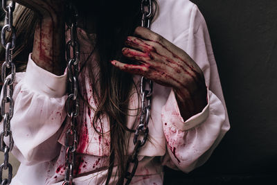 Midsection of woman with blood on hands
