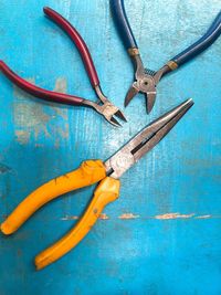 Directly above shot of pliers on blue table