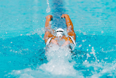 Rear view of woman swimming in pool