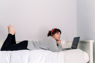 Woman using mobile phone on bed