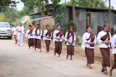 Group of people walking on street in city