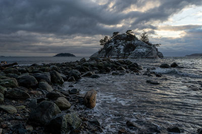 Rocks on beach against sky