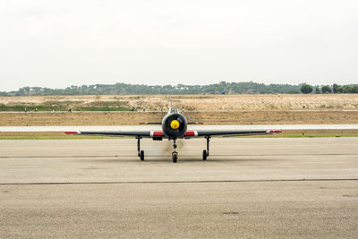 Airplane on runway against sky