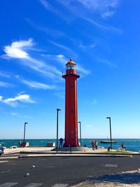 Lighthouse by sea against sky