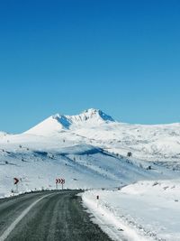 Scenic view of snowcapped mountains against clear blue sky