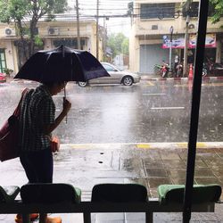 Man standing on wet street during monsoon