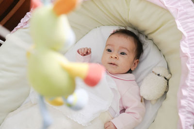 Cute baby boy looking at toy hanging