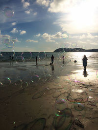 People at beach against sky