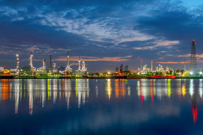 Illuminated factory against sky at night